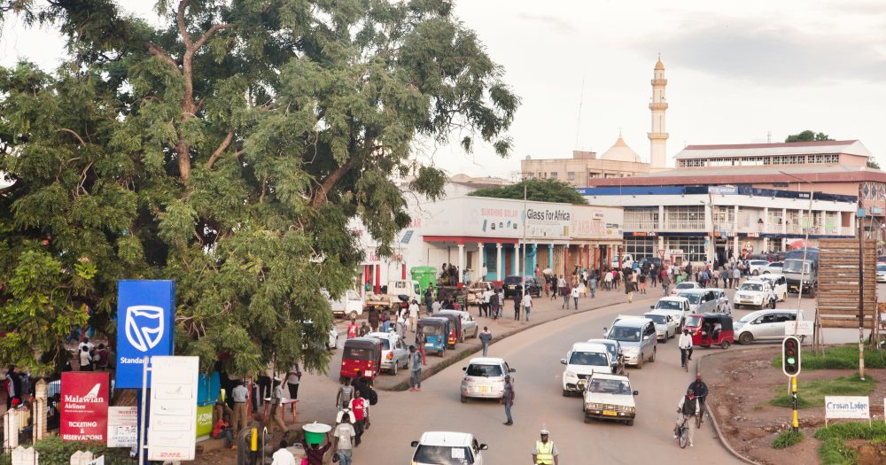 Busy street scene in Malawi with a mosque in the distance